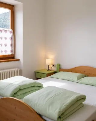 two twin beds in a room with a window at El Casel dei Masi in Grumes