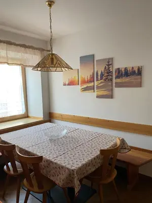 a dining room with a table and four chairs at El Polse - Appartmento per 5 persone in Ziano di Fiemme