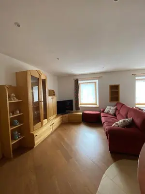 a living room with a red couch and a tv at El Polse - Appartmento per 5 persone in Ziano di Fiemme