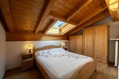 a bedroom with a large bed with a skylight at Residence Canazei in Alba di Canazei