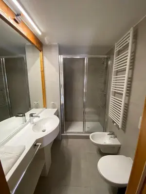 a bathroom with two sinks and a shower and a toilet at Residence Canazei in Alba di Canazei