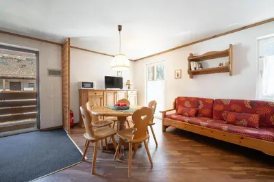 a living room with a red couch and a table at Residence Canazei in Alba di Canazei