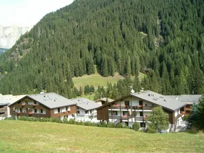 a group of buildings in front of a mountain at Residence Canazei in Alba di Canazei