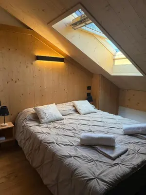 a large bed in a room with a window at Alloggio per Milano-Cortina 2026 a ValdiFiemme in Carano