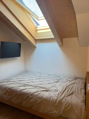 a bedroom with a bed and a flat screen tv at Alloggio per Milano-Cortina 2026 a ValdiFiemme in Carano