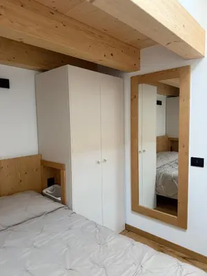 a bedroom with a bed and a mirror at Alloggio per Milano-Cortina 2026 a ValdiFiemme in Carano