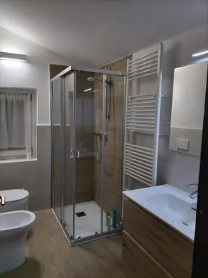 a bathroom with a shower and a toilet and a sink at El Zirum Boscoverde in Sottoguda