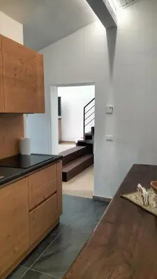 a kitchen with a wooden counter and a staircase at El Zirum Boscoverde in Sottoguda