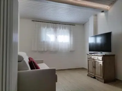 a living room with a couch and a flat screen tv at El Zirum Boscoverde in Sottoguda