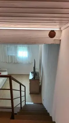 a room with a staircase with a television and a window at El Zirum Boscoverde in Sottoguda