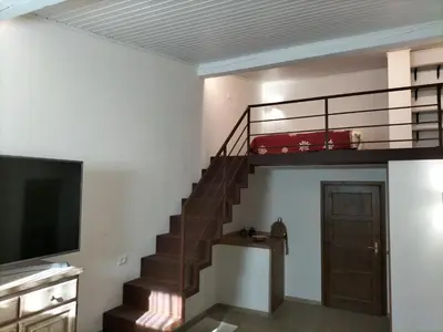 a living room with a staircase and a tv at El Zirum Boscoverde in Sottoguda