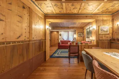 a room with wooden walls and a table and chairs at Casa Bucaneve 2, confortevole a due passi dal centro in Cortina dʼAmpezzo