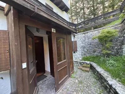 an entrance to a building with a wooden door at Casa Bucaneve 2, confortevole a due passi dal centro in Cortina dʼAmpezzo