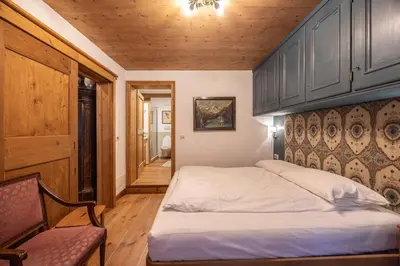 a bedroom with a bed and a wooden ceiling at Casa Bucaneve 2, confortevole a due passi dal centro in Cortina dʼAmpezzo