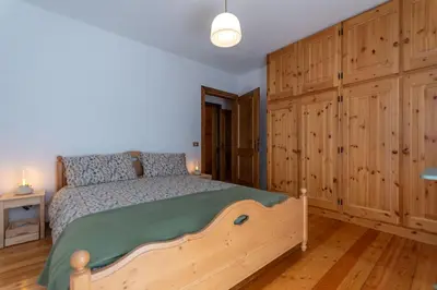 a kitchen with wooden cabinets and a black dishwasher at Sunshine Home in Caprile