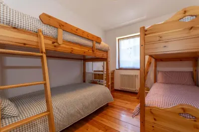 a bedroom with a wooden bed and wooden cabinets at Sunshine Home in Caprile