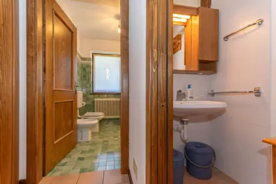 a bathroom with a sink and a small refrigerator at Sunshine Home in Caprile