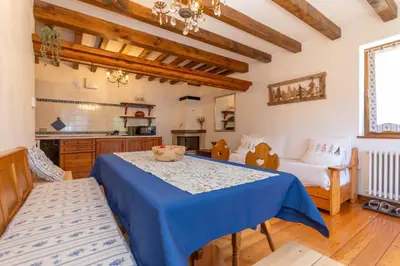 a living room with a blue table and chairs at Sunshine Home in Caprile