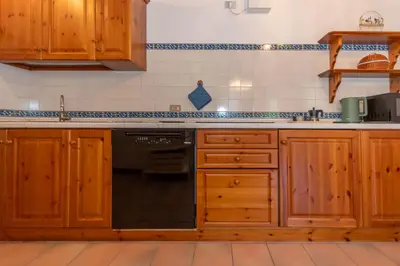 a kitchen with wooden cabinets and a counter top at Sunshine Home in Caprile