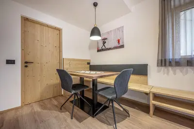 a dining room with a wooden table and chairs at Apartments Raffl in Ortisei