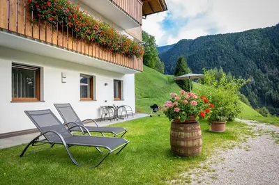 a group of chairs sitting on a lawn next to a building at Apartments Raffl in Ortisei