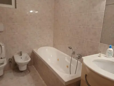 a bathroom with a tub and a toilet and a sink at Casa Soppelsa 1 in Moena