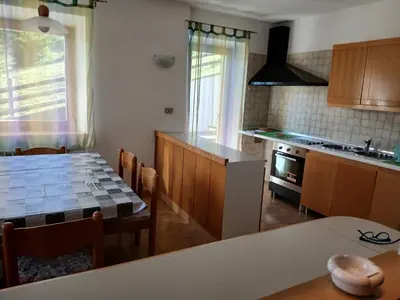 a kitchen and dining room with a table and a dining room gmaxwell gmaxwell at Casa Soppelsa 1 in Moena