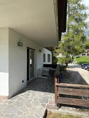 a porch of a house with a bench next to it at Dimora Alverà 19 in Cortina dʼAmpezzo