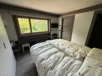 a bedroom with a white bed and a window at Dimora Alverà 19 in Cortina dʼAmpezzo