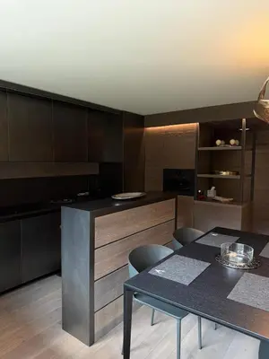 a kitchen with a table and chairs and cabinets at Dimora Alverà 19 in Cortina dʼAmpezzo