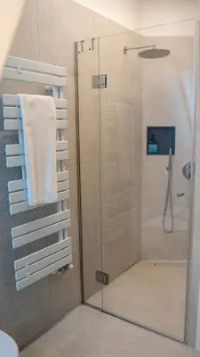 a shower with a glass door in a bathroom at Talvera Dream - City center, Rooftop, Garage & Jacuzzi in Bolzano
