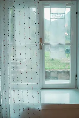 a window with a white curtain and a window sill at Dhea's Little House in Bolzano