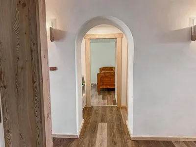 a hallway with an archway and a dresser in a room at Dhea's Little House in Bolzano