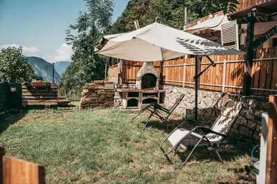an umbrella and chairs in a yard with a fireplace at Dhea's Little House in Bolzano