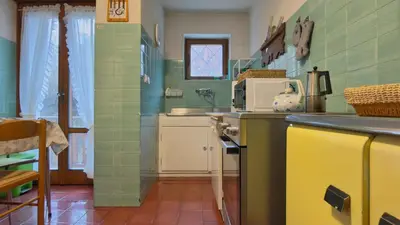 a kitchen with green tile walls and a counter top at Homeby, Ca' Del Molin in Cortina dʼAmpezzo
