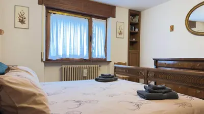 a bedroom with a bed with towels on it at Homeby, Ca' Del Molin in Cortina dʼAmpezzo