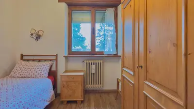 a small bedroom with a bed and a window at Homeby, Ca' Del Molin in Cortina dʼAmpezzo