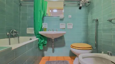 a bathroom with a sink and a toilet and a tub at Homeby, Ca' Del Molin in Cortina dʼAmpezzo