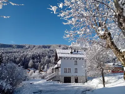 a white house with snow on its roof at Dolomites Garden Flat near Cortina in Villanova