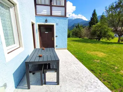 a wooden picnic table sitting outside of a house at Dolomites Garden Flat near Cortina in Villanova