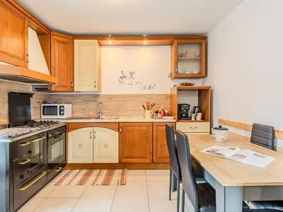 a kitchen with wooden cabinets and a wooden table at Apartment Relax tra i Monti by Interhome in Livo