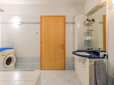 a bathroom with a sink and a wooden door at Apartment Relax tra i Monti by Interhome in Livo