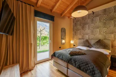 a bedroom with a bed and a large window at Villa Ilaria in Lagundo