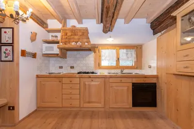 a kitchen with wooden cabinets and a sink at Serrai Lodge in Sottoguda