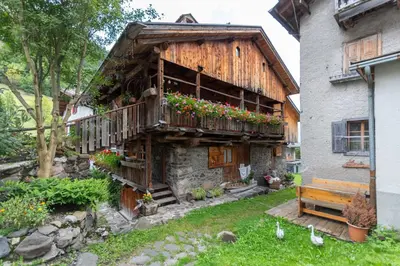 a building with a balcony with flowers on it at Serrai Lodge in Sottoguda