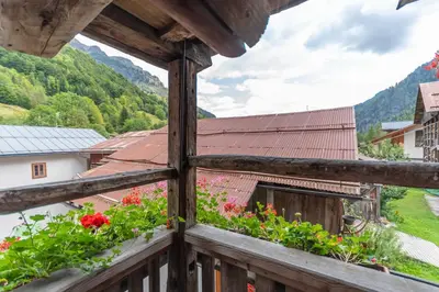 a view from a window of a house with flowers at Serrai Lodge in Sottoguda