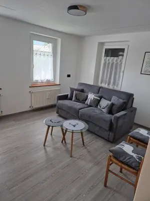 a living room with a couch and two tables at Casa Celeste Dolomiti in Frassenè