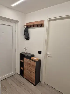 a room with a closet with a wooden cabinet and a door at Casa Celeste Dolomiti in Frassenè