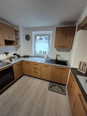 a kitchen with wooden cabinets and a sink and a window at Casa Celeste Dolomiti in Frassenè