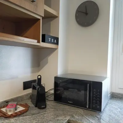 a microwave sitting on top of a counter with a clock at Casa Celeste Dolomiti in Frassenè